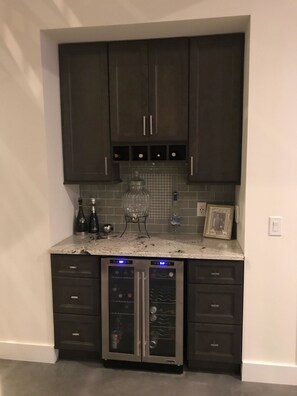 Compact kitchen with wine cooler and digital display.