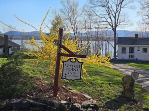 Une enseigne indiquant l’emplacement du « Watch Point Inn & Cottages », avec en arrière-plan une vue sur un lac et des montagnes.
