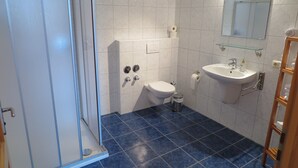 Un baño con inodoro, lavamanos y ducha.