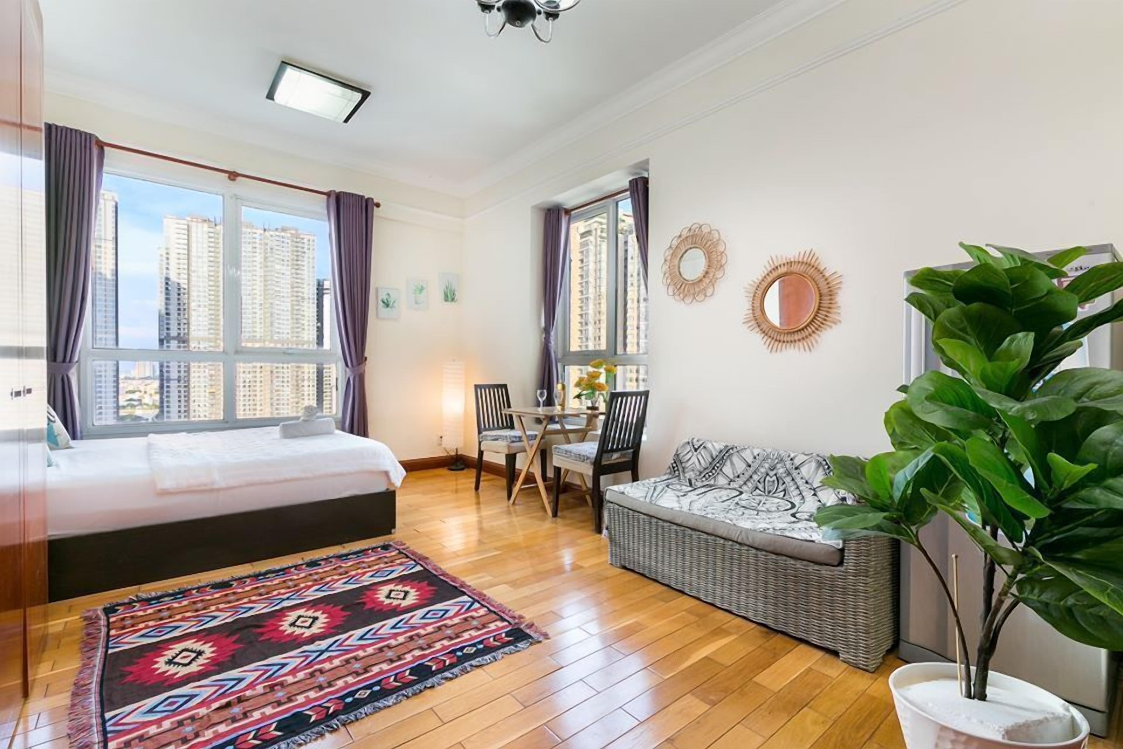 A modern bedroom with a large bed, a dining area, and a living space.