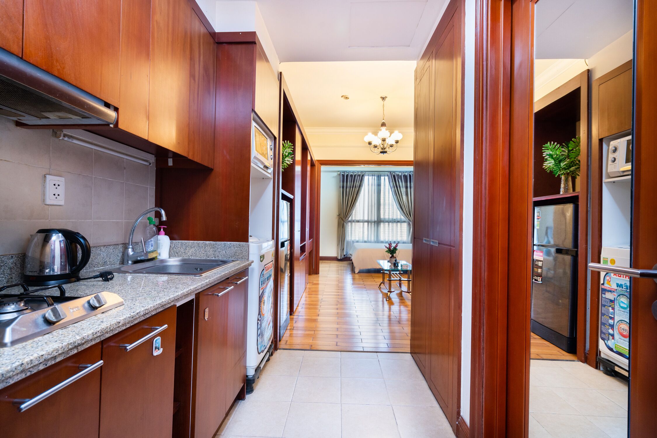 A modern kitchen with wooden cabinets, a granite countertop, and a built-in stove.