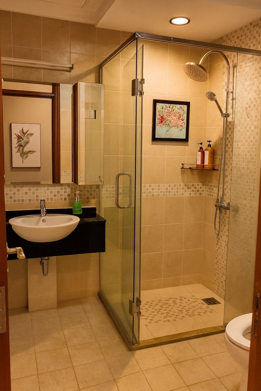 A bathroom with a glass-enclosed shower, a sink with a black countertop, and a toilet.