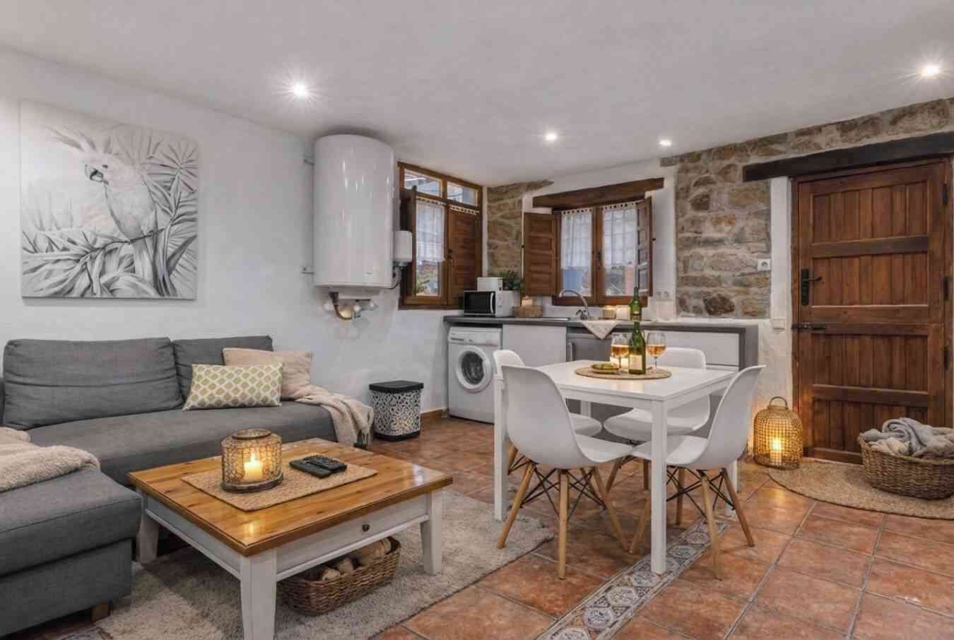 A cozy living room with a sofa, coffee table, and a dining area with chairs and a table.