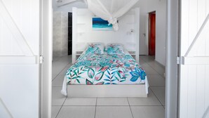 A bedroom with a bed, a canopy, a painting, and a wardrobe. - Villa l'Amazonia 5 *, luxury villa rental in Deshaies in Guadeloupe: (Deshaies)
