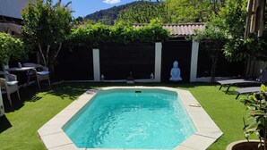 A rectangular pool with a tiled border, surrounded by artificial grass, with a white statue and a pergola in the background. - house with pool in beausset (Le Beausset)
