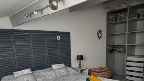 A bedroom with a large bed, a wardrobe, a nightstand, and a ceiling light fixture. - house with pool in beausset (Le Beausset)