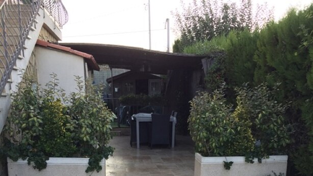 A paved courtyard with two planters on either side, a covered seating area, and a staircase leading to a building. - house with pool in beausset (Le Beausset)