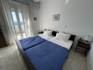 A hotel room with two beds, a balcony, and a view of the sea. - Big infinity private pool (10mtx4mt)★Sea view★Big sea view terrace 100m2★ (Kokkino Chorio)