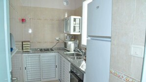 A compact kitchen with a microwave, stove, sink, and a refrigerator. - City Apartment on the port of Mahdia Free Wifi (Mahdia)
