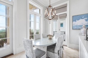 Enjoy dining in this stylish space with a round table, comfortable chairs, and a beautiful seascape painting.