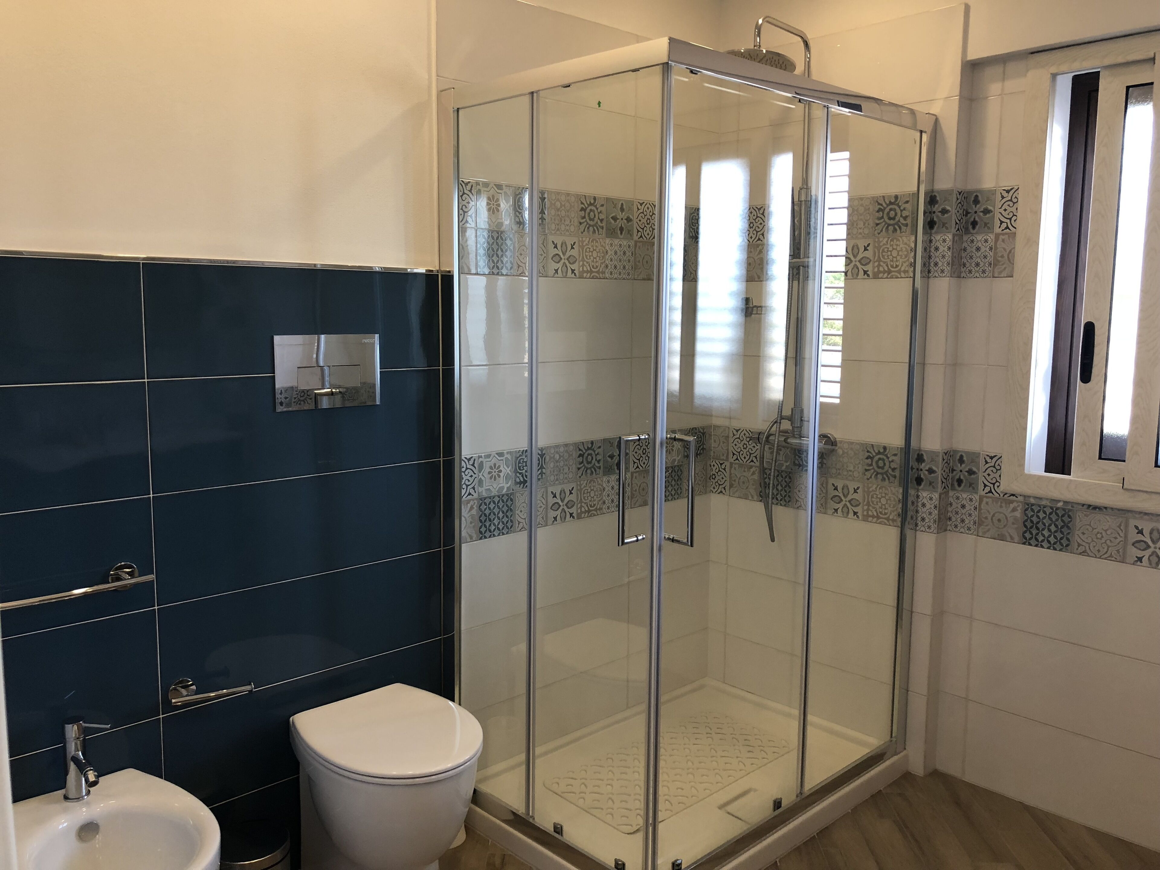 Ein Badezimmer mit einer Duschkabine, einer weißen Toilette und einem Bidet.