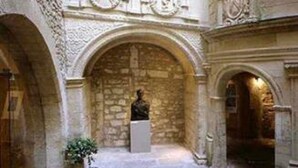 An interior courtyard with stone arches, a statue, and a clock. - Vacation (SAINT REMY DE PROVENCE)