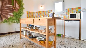A kitchen with a wooden shelf holding pots and pans, a microwave, and a dishwasher. - House 7 persons  with large pool in corbieres area (Talairan)