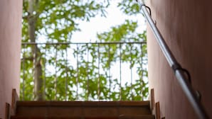 A staircase with a metal handrail leading to a balcony with a view of green trees. - B&B with pool, only one step away from Assisi (Bastia Umbra/Assisi)