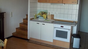 A compact kitchen with white cabinets, a built-in oven, and a sink. - Curr. M.Flair, quiet location, grGarten, fenced.2km, directly to the forest / meadow, gr. Lake (Blankenheim-Reetz)