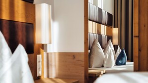 Une chambre d’hôtel avec une tête de lit en bois, une table de chevet et une lampe.