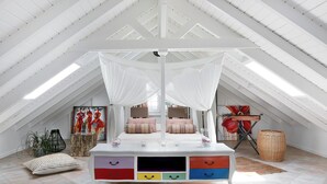 A bedroom with a canopy bed, a painting, and a wicker basket. - Domaine de Néron - Ti-Punch (Le Moule)