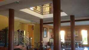 Un vestíbulo espacioso con una escalera, un comedor y una zona de estar con un sofá azul y naranja.