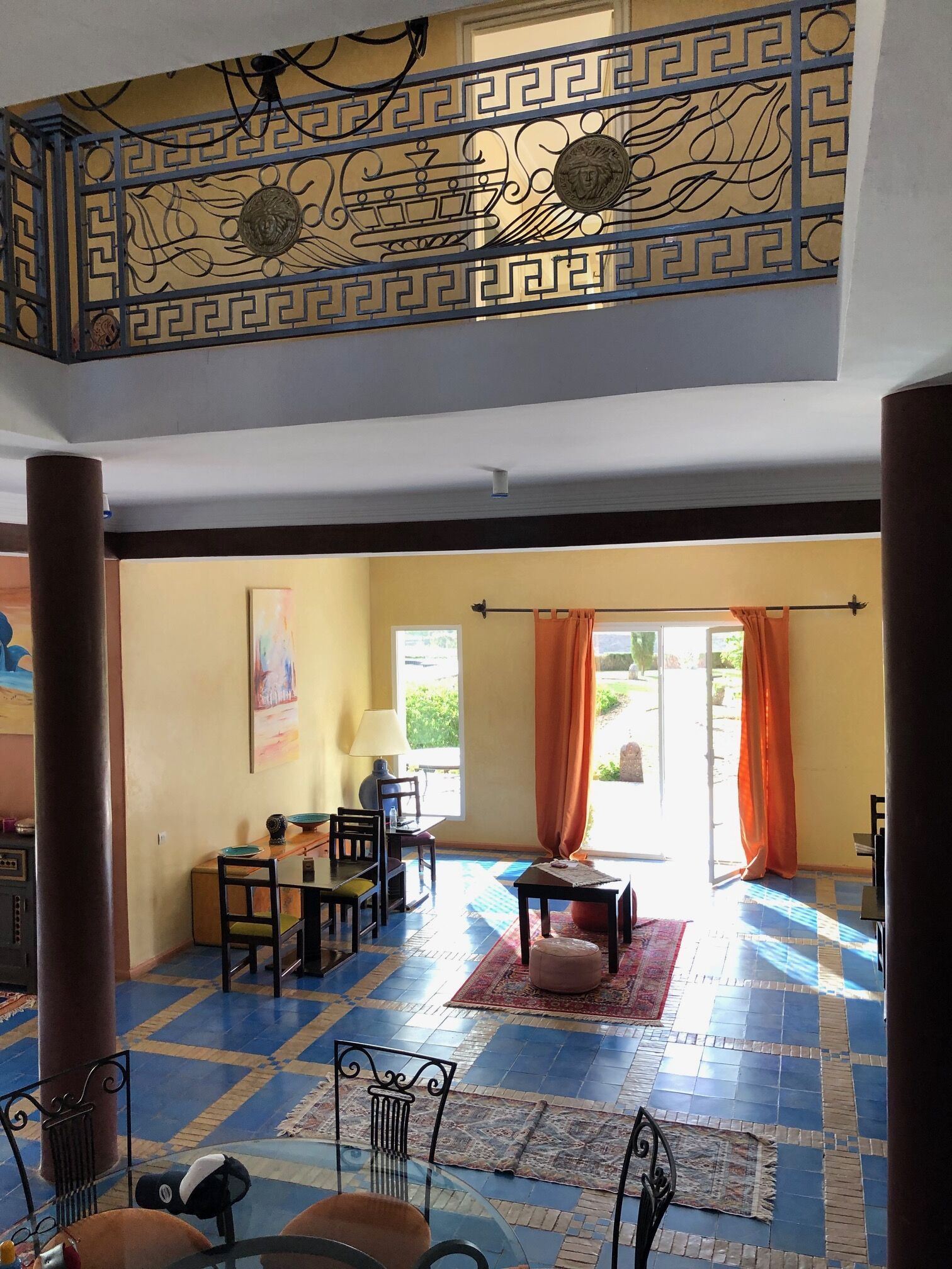 Une pièce spacieuse avec un plafond décoré, un coin repas comprenant une table et des chaises, et une vue sur l’extérieur grâce à une grande fenêtre.