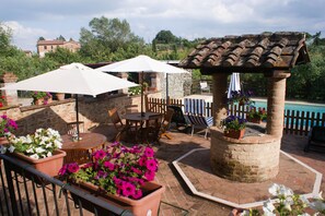 An outdoor patio with a pool, stone walls, and potted plants. - Romantic two-room apartment overlooking the Sienese countryside (Sant'Andrea A Montecchio)