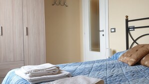 A bedroom with a bed, a wardrobe, and a door. - Romantic two-room apartment overlooking the Sienese countryside (Sant'Andrea A Montecchio)