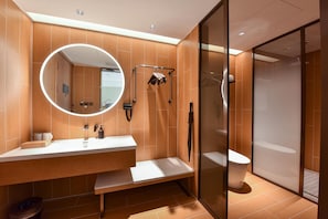 Une salle de bain moderne avec un grand miroir, une douche et des toilettes.