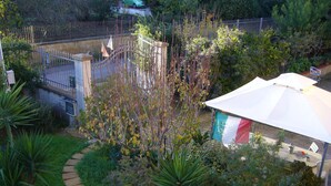 Ein Garten mit Spielbereich, einem eingezäunten Bereich und einem weißen Zelt.
