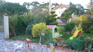A paved patio with a pink bicycle, a children's playhouse, and a slide. - B & B St. ELIA suite ROSA: CHARMING VILLA IMMERSED IN THE HISTORIC PARK DUBINI (caltanissetta)