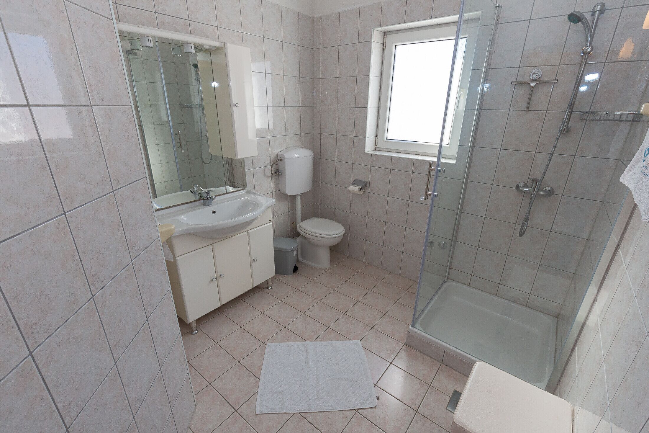 Een douche, handdoeken, zeep, toiletpapier