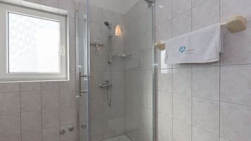 Een douche, handdoeken, zeep, toiletpapier