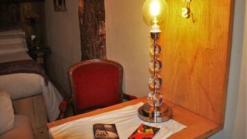 A wooden table with a lamp, a chair, and two pamphlets.