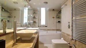 Ein modernes Badezimmer mit zwei Waschbecken, einer Badewanne und einer Dusche.
