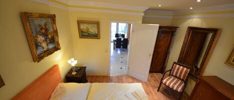 A bedroom with a bed, a nightstand, a chair, and a wooden cabinet.