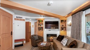 Ein gemütliches Wohnzimmer mit Kamin, bequemen Sitzgelegenheiten und einem Fernseher.