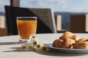 Ein Tisch mit einem Glas Orangensaft, einer Teller Keksen und einigen weißen Blumen.
