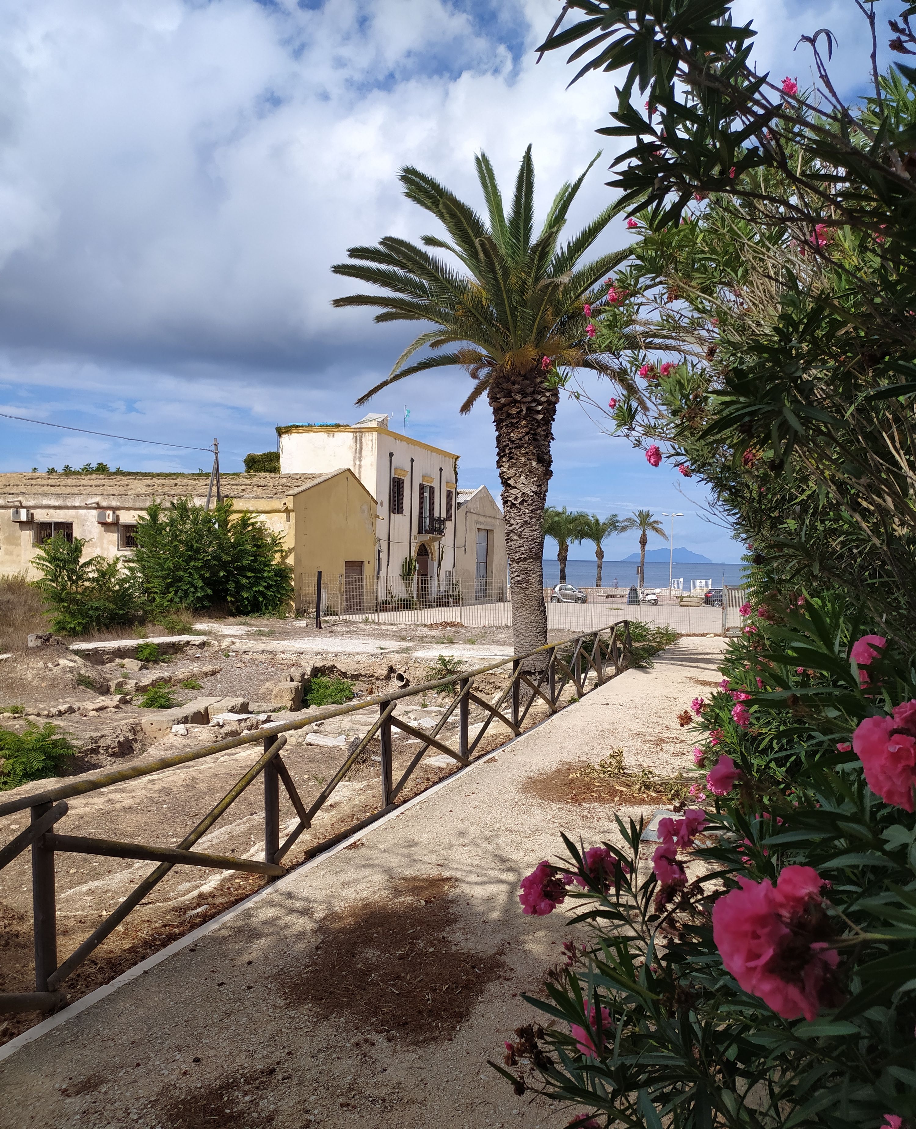 Un sentier menant à un bâtiment offrant une vue sur la côte.