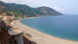 Una playa costera con un muro de piedra y una carretera que lleva a la playa.