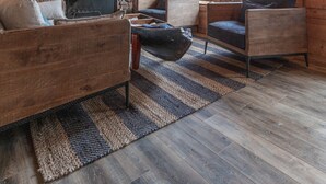 A cozy log cabin interior with a stone fireplace, wooden furniture, and large windows. - Technology Free & Dogs are Welcome (Lake City)