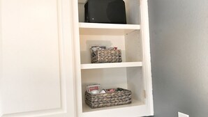 A white cabinet with three shelves, each containing different items. - The Monticello Guest House - Charming M Streets - Dallas (Dallas)
