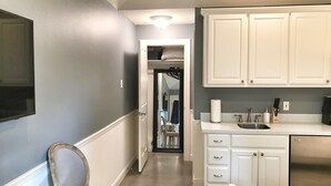 A kitchen with white cabinets, a stainless steel refrigerator, and a countertop with a sink. - The Monticello Guest House - Charming M Streets - Dallas (Dallas)