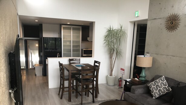 A modern living room with a sofa, coffee table, and dining area. - Chakashiya Goten (Onna)