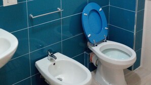 A bathroom with blue tiled walls, a white sink, a bidet, and a toilet. - Lilla'S House Apartment (Caltanissetta)