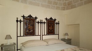 A bedroom with a bed, two nightstands, and two wall-mounted picture frames.