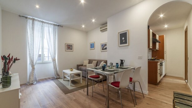 Un appartamento moderno con zona pranzo, cucina e soggiorno.