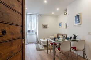 Un comedor con un aparador de madera, una mesa de comedor con sillas y un sofá.