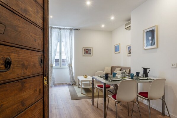 Un comedor con un aparador de madera, una mesa de comedor con sillas y un sofá.