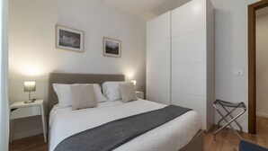 Una camera da letto moderna con un letto grande, comodini e un armadio.