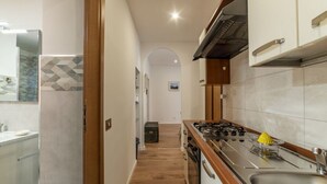 A modern kitchen with a central island, stainless steel appliances, and a view into the dining area. - Modern, cozy and comfortable by Fontana di Trevi (Roma)