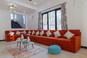 Relax in this stylish living room with a vibrant sofa, glass coffee table, and colorful rug.