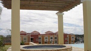 A covered outdoor area with a swimming pool, surrounded by buildings with red and yellow facades.